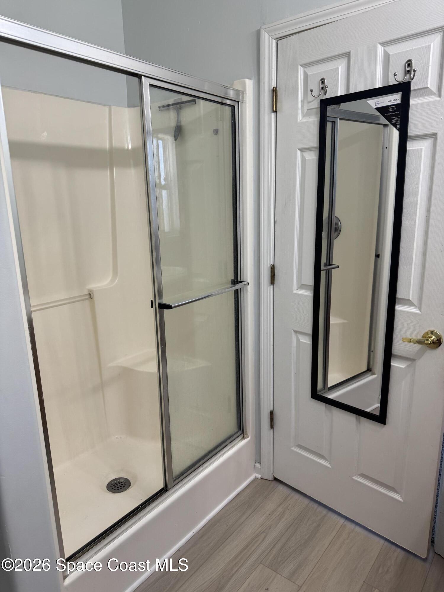 1130 Grapefruit Road Southeast Palm Bay, FL 32909 - Photo 10 of 14 a bathroom with a glass shower door and a mirror
