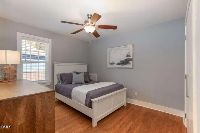 a bedroom with a bed and a mirror on the dresser