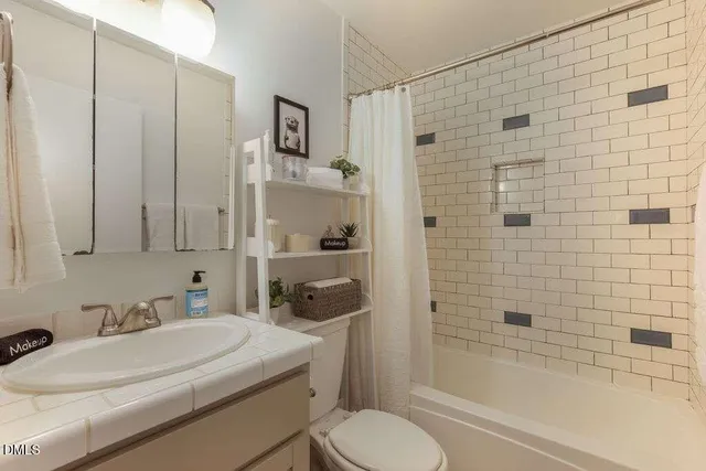 a bedroom with a bed and a flat tv screen on a dresser