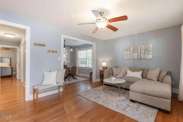 a living room with furniture a clock and a window