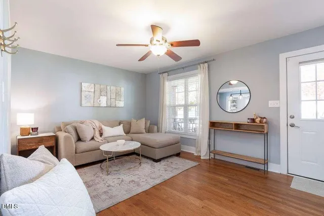 a living room with furniture a flat screen tv and a window