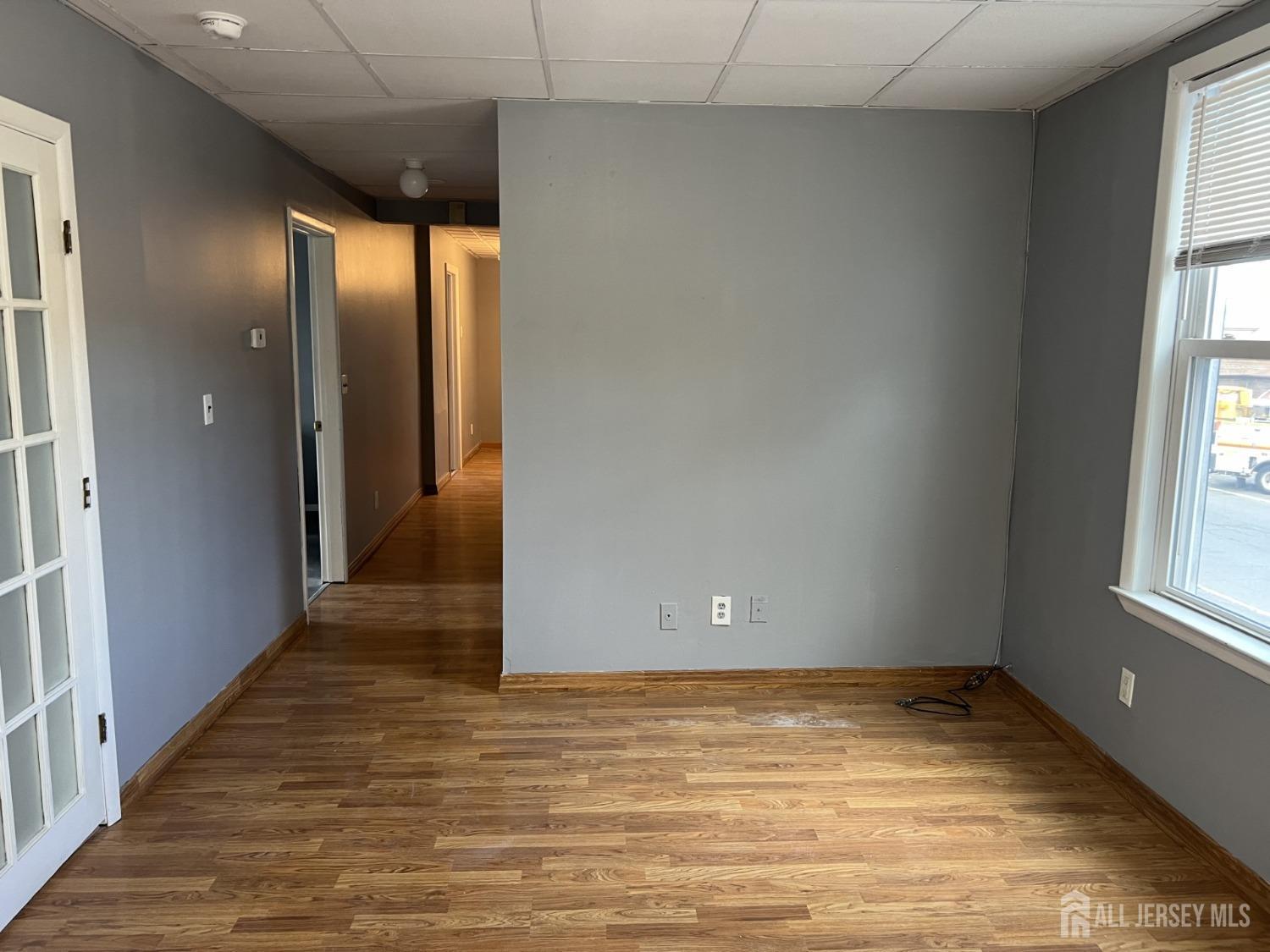 247 Washington Avenue, Unit 2F Carteret, NJ 07008 - Photo 3 of 10 an empty room with wooden floor and windows