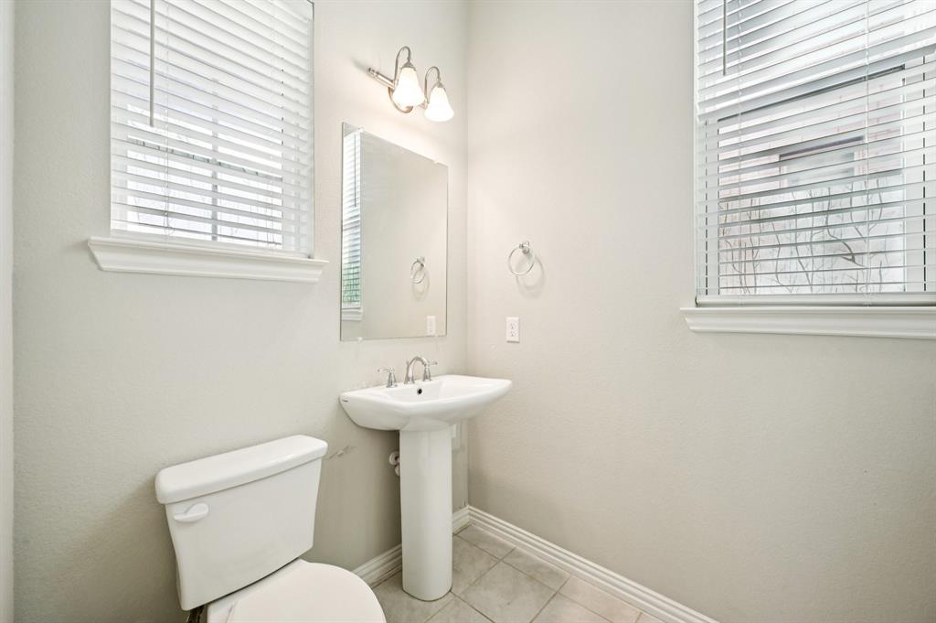 8039 Copper Way Dallas, TX 75252 - Photo 15 of 30 a white toilet sitting next to a bathroom sink