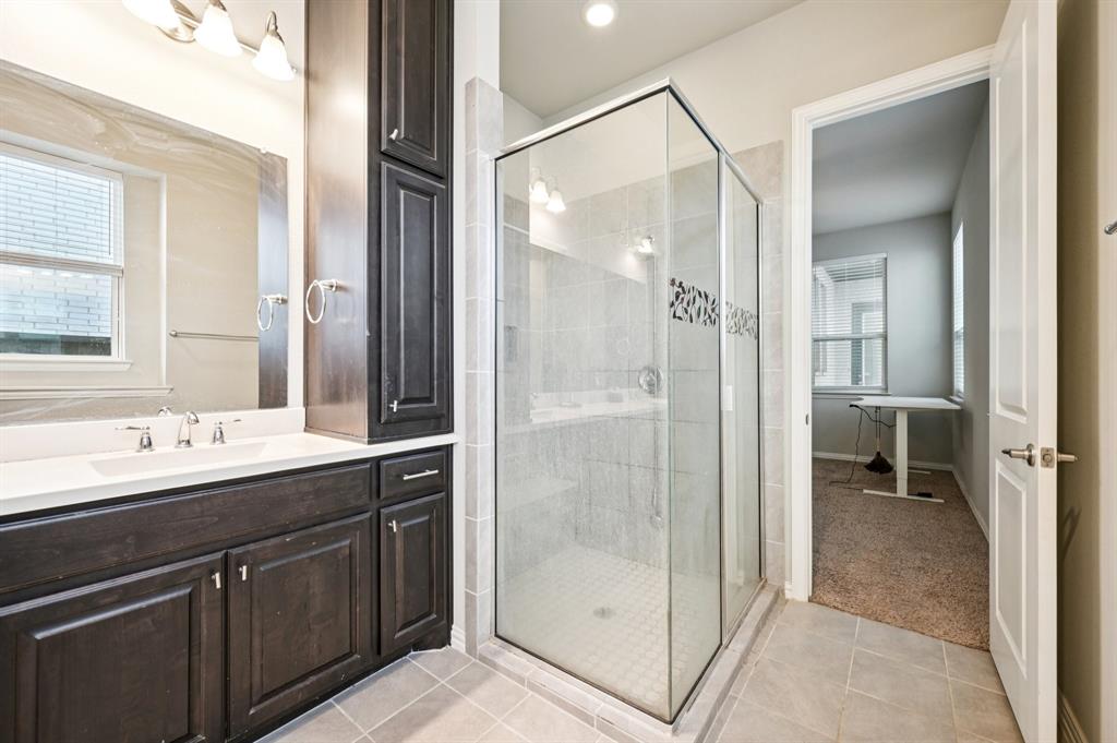 8039 Copper Way Dallas, TX 75252 - Photo 20 of 30 a bathroom with a shower sink and mirror
