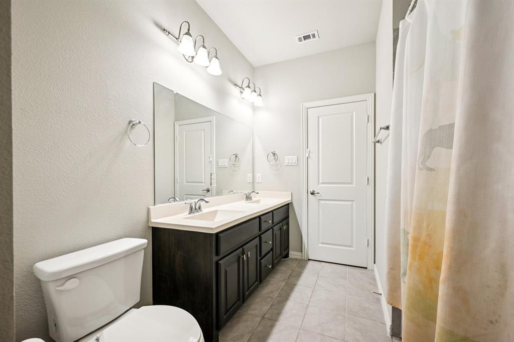 8039 Copper Way Dallas, TX 75252 - Photo 27 of 30 a bathroom with a toilet sink and mirror