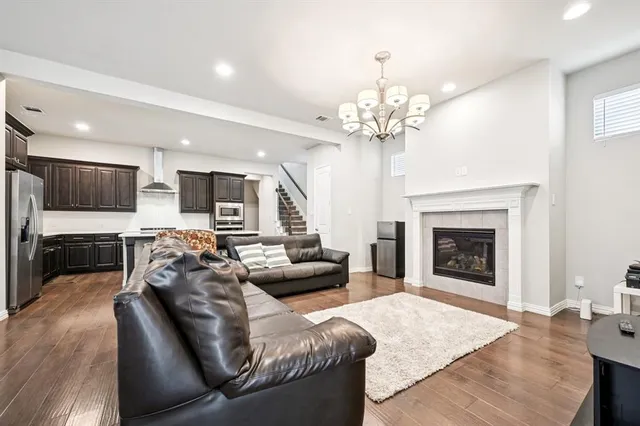 a living room with furniture a fireplace and a chandelier