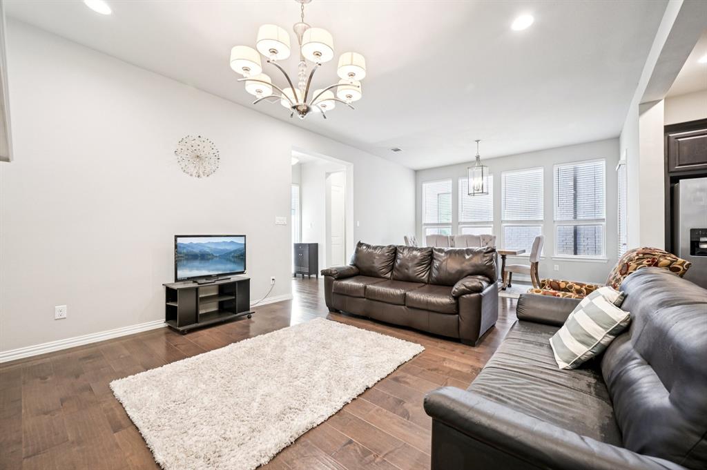 8039 Copper Way Dallas, TX 75252 - Photo 6 of 30 a living room with furniture a fireplace and a flat screen tv