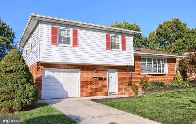 a front view of a house with a yard and potted plants