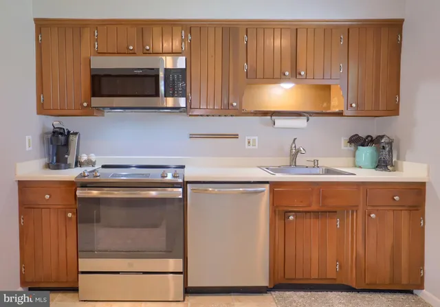 a kitchen with stainless steel appliances granite countertop a sink microwave and stove top oven