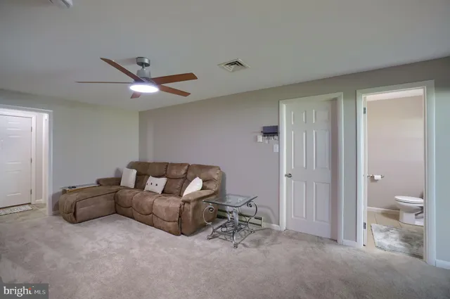 a living room with furniture and a ceiling fan