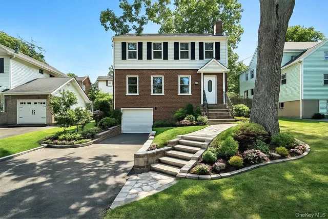 a front view of a house with a yard and outdoor seating