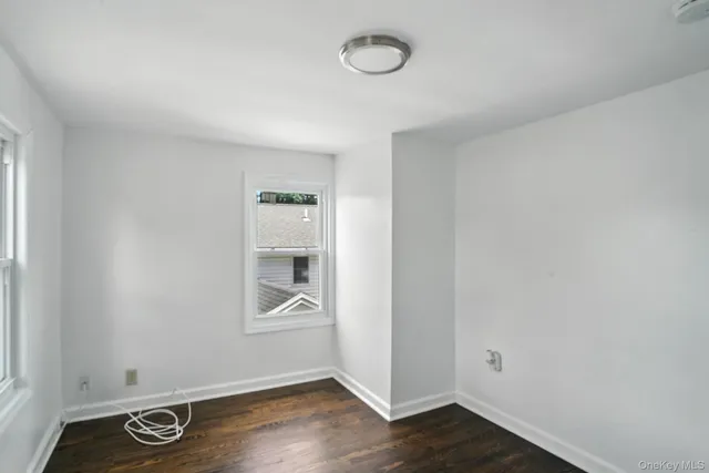 an empty room with wooden floor and window