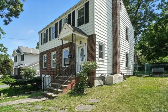 a view of a house with backyard and sitting area