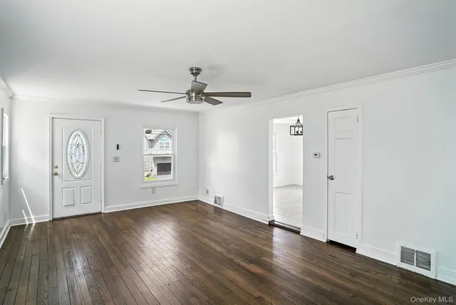 a view of empty room with wooden floor