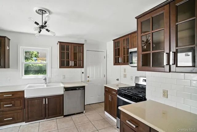 a kitchen with a stove sink and cabinets