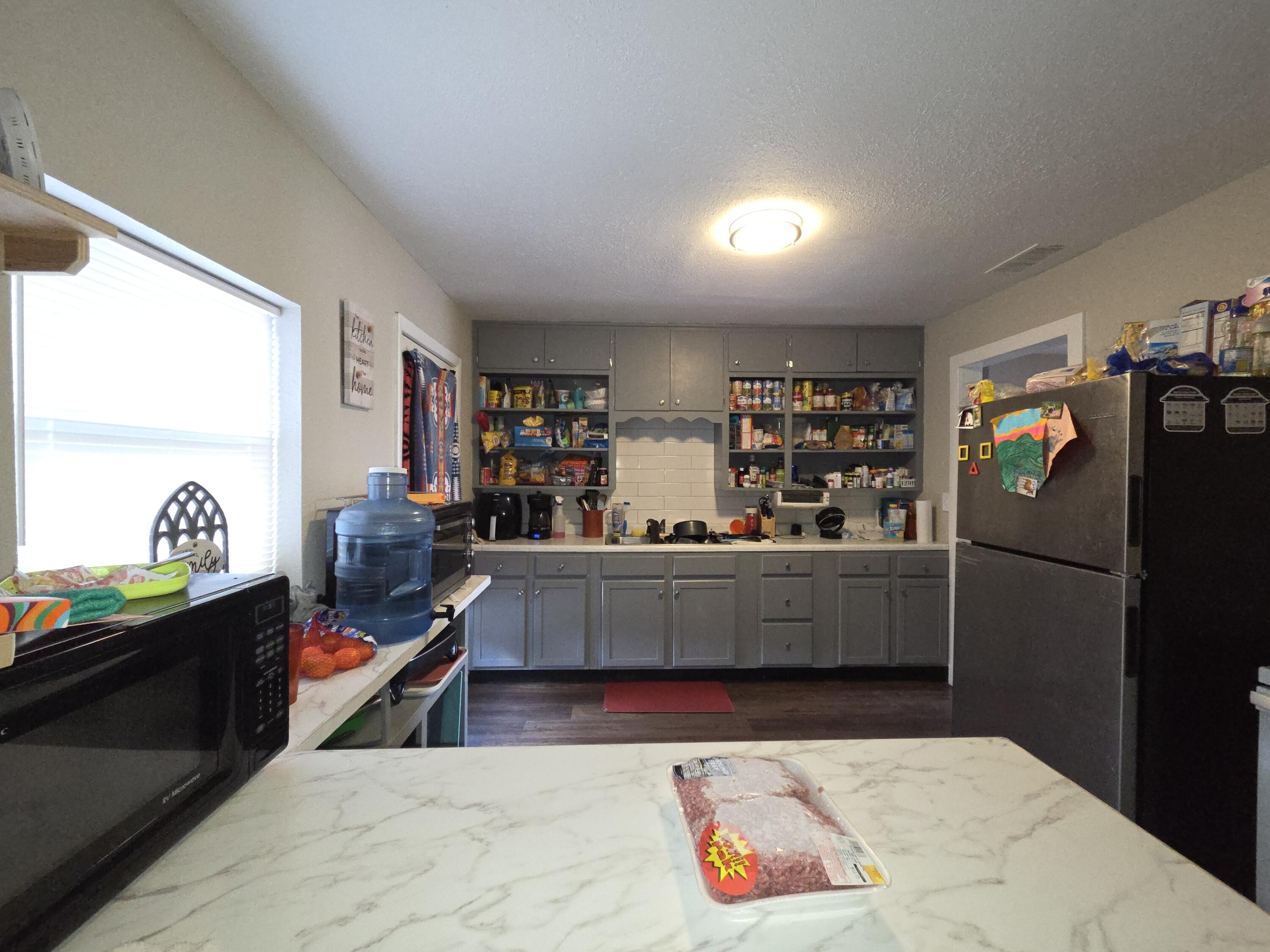 a kitchen with stainless steel appliances kitchen island granite countertop a refrigerator and a stove