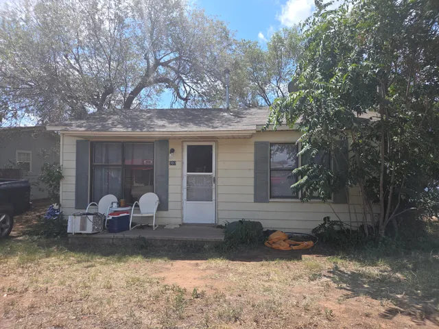 a front view of a house with yard and sitting area
