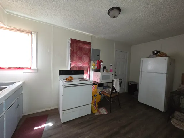 a room with a refrigerator and a stove top oven