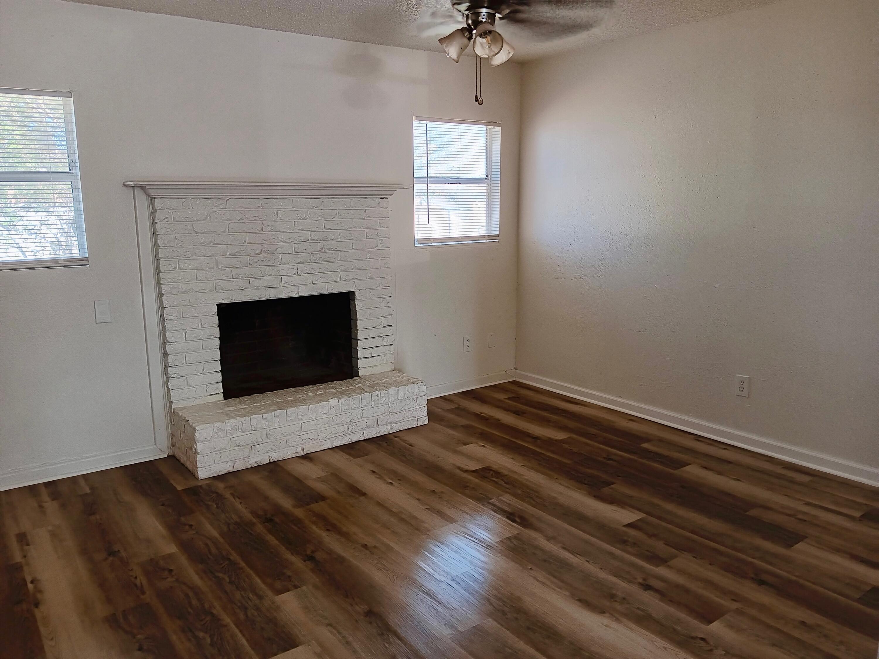 Turn-key St Lubbock Tx 79403 Lubbock, TX 79411 - Photo 9 of 18 wooden floor fireplace and windows in an empty room