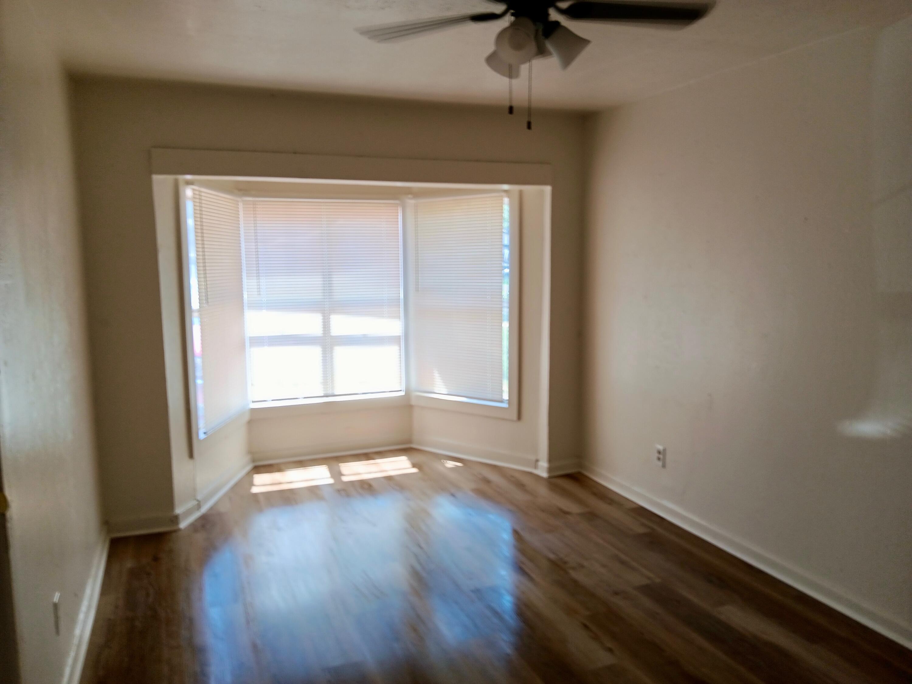 Turn-key St Lubbock Tx 79403 Lubbock, TX 79411 - Photo 10 of 18 an empty room with wooden floor and windows