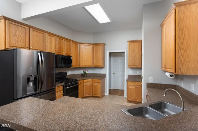 a kitchen with stainless steel appliances granite countertop a stove a refrigerator and a microwave