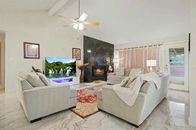 a living room with furniture a fireplace and a chandelier