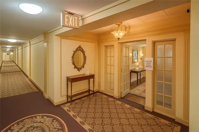 a view of a hallway with wooden floor and a bathroom