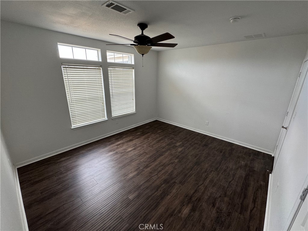 57725 Ramsey Road Anza, CA 92539 - Photo 22 of 43 an empty room with wooden floor fan and windows