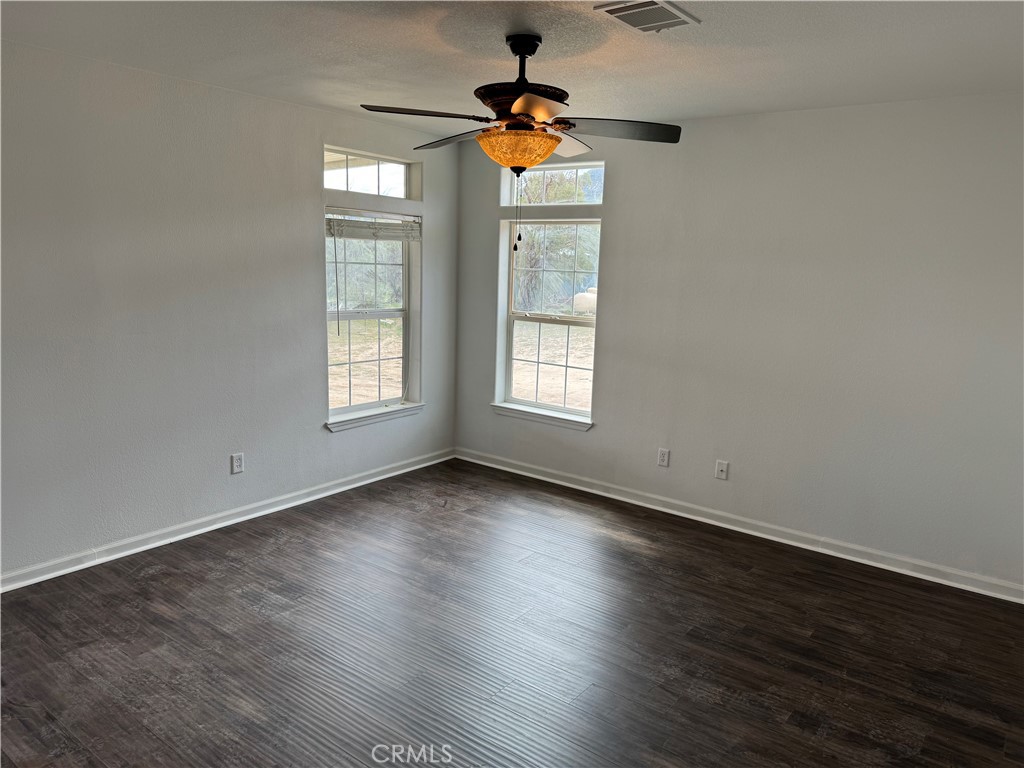 57725 Ramsey Road Anza, CA 92539 - Photo 5 of 43 an empty room with wooden floor ceiling fan and windows
