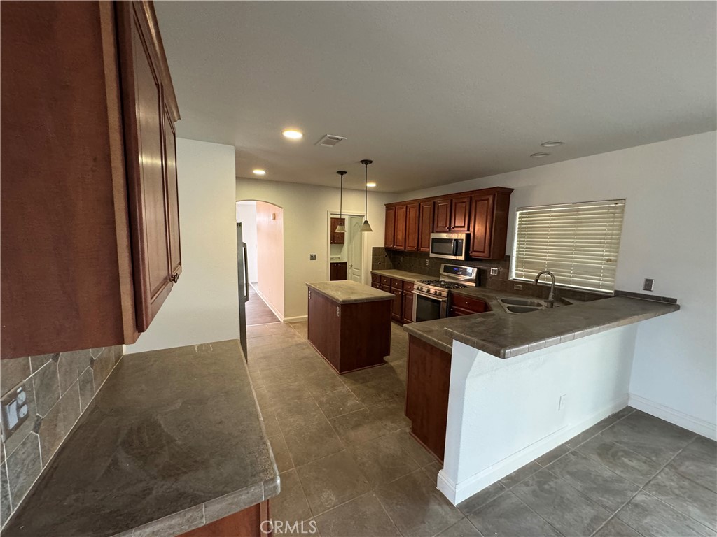 57725 Ramsey Road Anza, CA 92539 - Photo 6 of 43 a kitchen with stainless steel appliances granite countertop a stove top oven a sink a refrigerator and a granite counter tops
