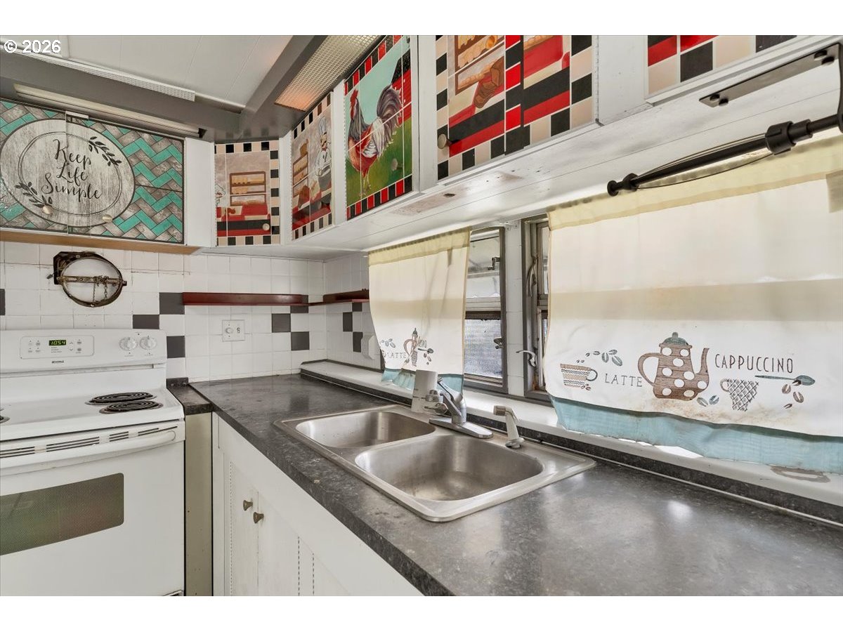 5422 Portland Road Northeast, Unit 10 Salem, OR 97305 - Photo 13 of 25 a kitchen with stainless steel appliances granite countertop a sink and a microwave