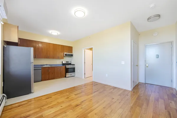 a kitchen with stainless steel appliances kitchen island granite countertop a refrigerator and a sink