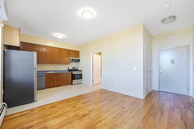 a kitchen with stainless steel appliances kitchen island granite countertop a refrigerator and a sink