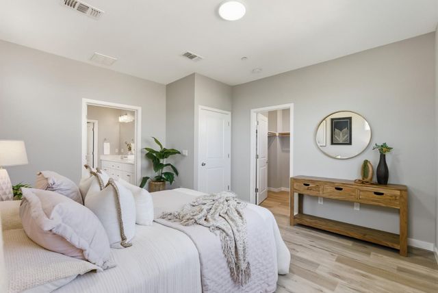 a bedroom with a bed a mirror and lamp on desk