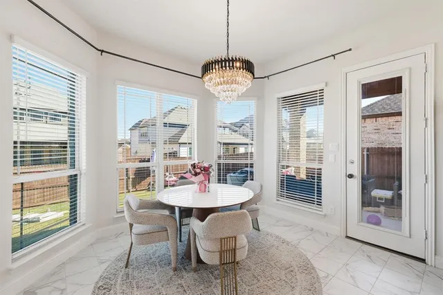 a dining room with furniture a chandelier and window