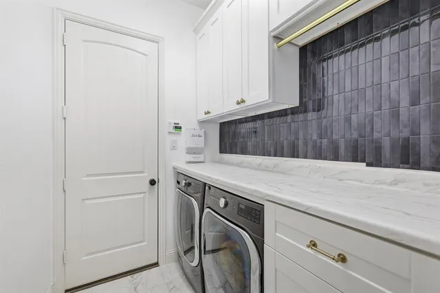 a utility room with washing machine and cabinets