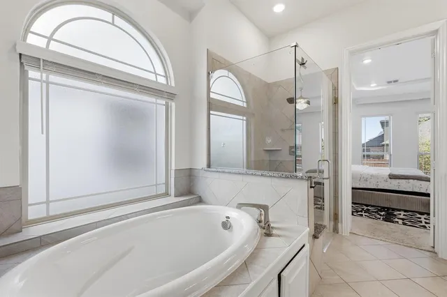 a bathroom with a tub a sink and a mirror