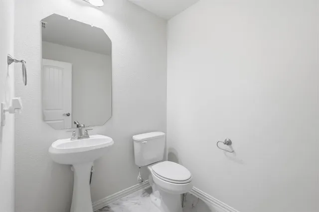 a bathroom with a sink a toilet and mirror