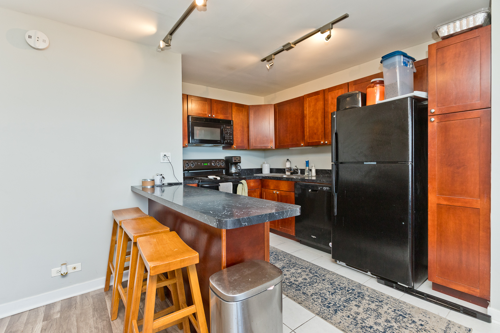 655 West Irving Park Road, Unit 4008 Chicago, IL 60613 - Photo 2 of 16 a kitchen with stainless steel appliances granite countertop a refrigerator a stove and a sink with wooden floor