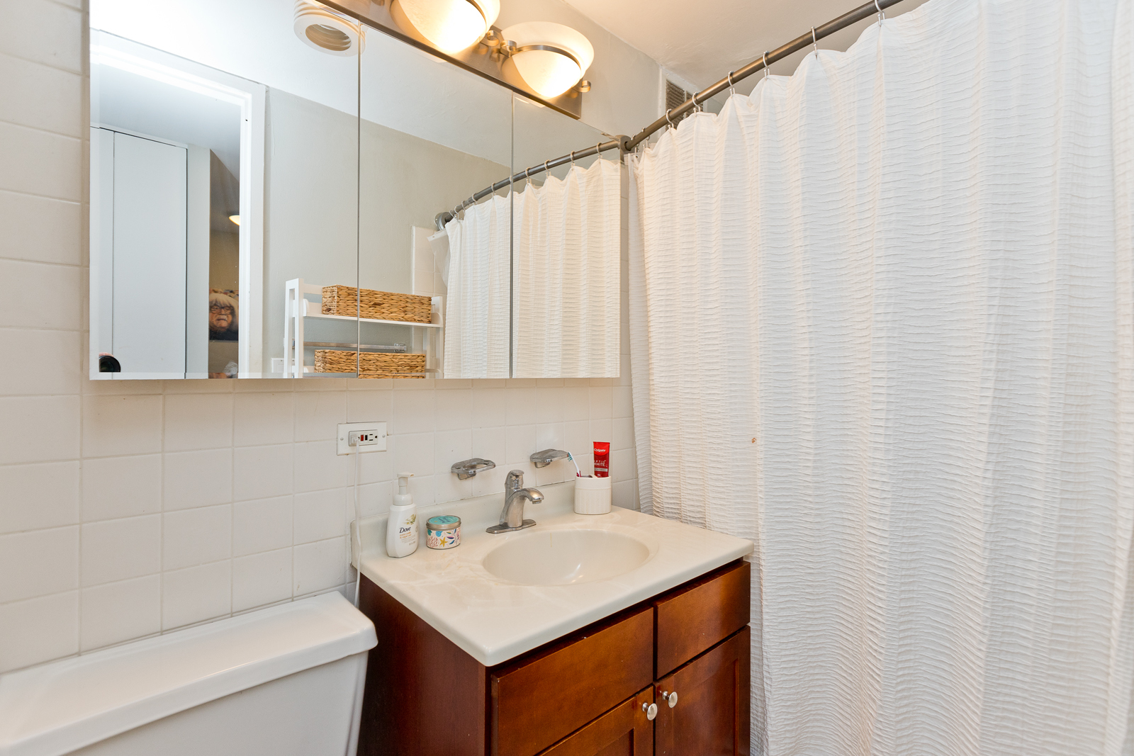 655 West Irving Park Road, Unit 4008 Chicago, IL 60613 - Photo 9 of 16 a bathroom with a sink a toilet and a mirror