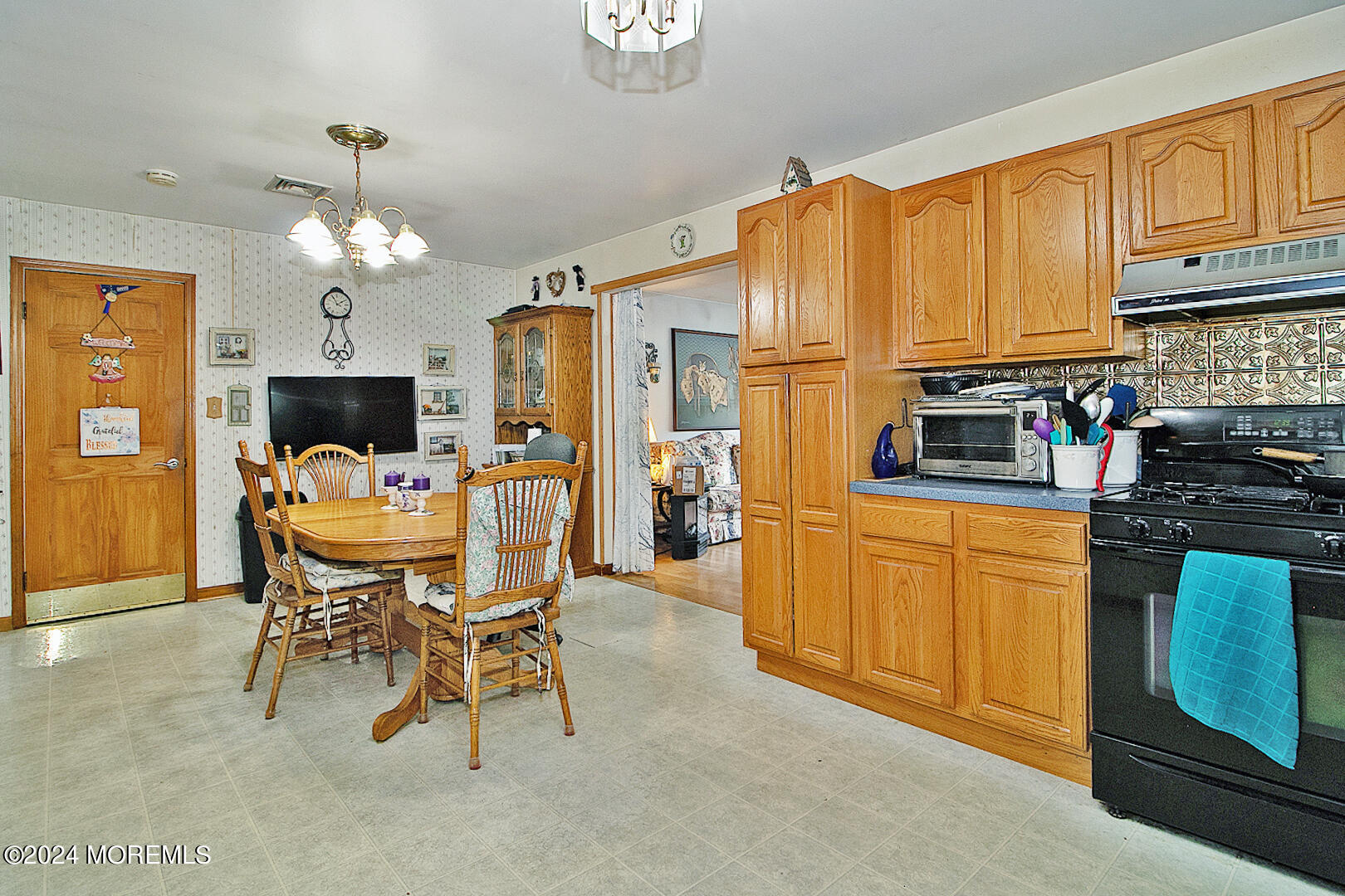 27 Barnegat Beach Drive Waretown, NJ 08758 - Photo 9 of 23 a kitchen with stainless steel appliances granite countertop a stove top oven a refrigerator a dining table and chairs with wooden floor