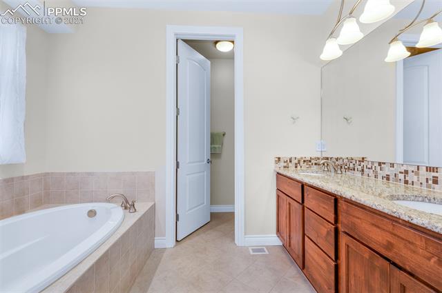 6980 Wildridge Road Colorado Springs, CO 80908 - Photo 11 of 26 5-pc master bath has soaking tub, granite counter, twin vanity sinks and a stall shower.