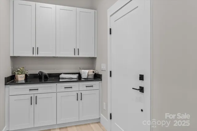 a kitchen with white cabinets and sink