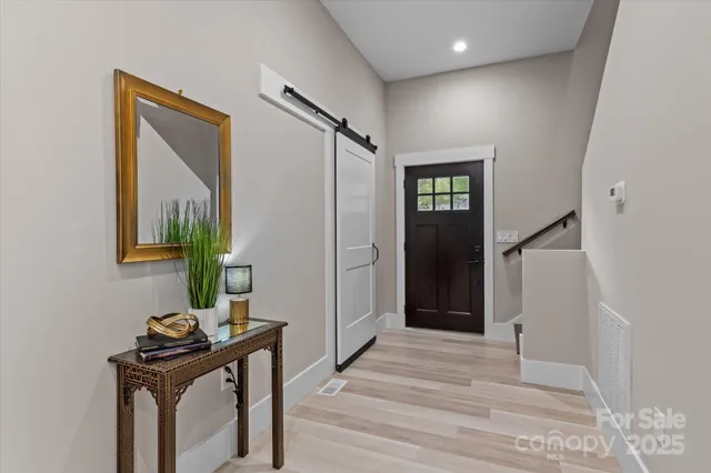 a view of a hallway with wooden floor and windows