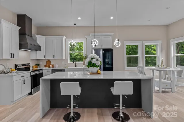 a kitchen with kitchen island granite countertop a sink and a refrigerator