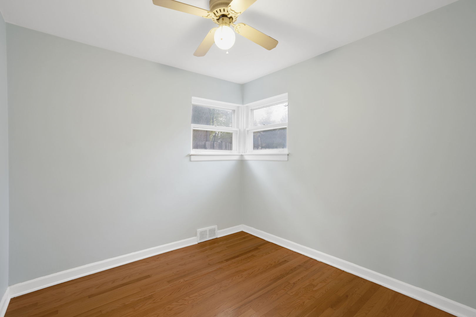 2402 Illinois Road Northbrook, IL 60062 - Photo 7 of 9 an empty room with a window and wooden floor