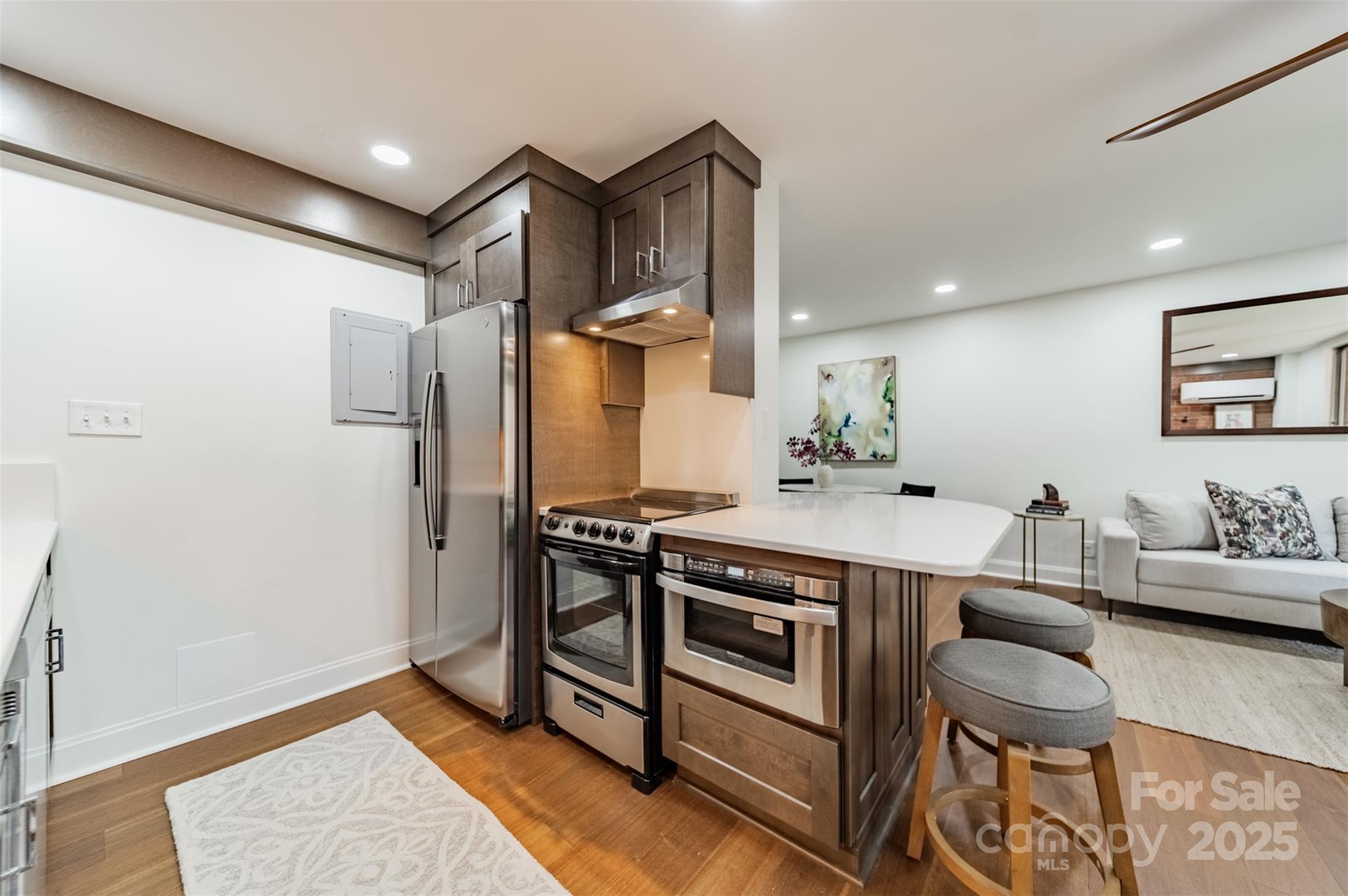 400 Queens Road, Unit D6 Charlotte, NC 28207 - Photo 7 of 26 a kitchen with stainless steel appliances a table chairs and a refrigerator