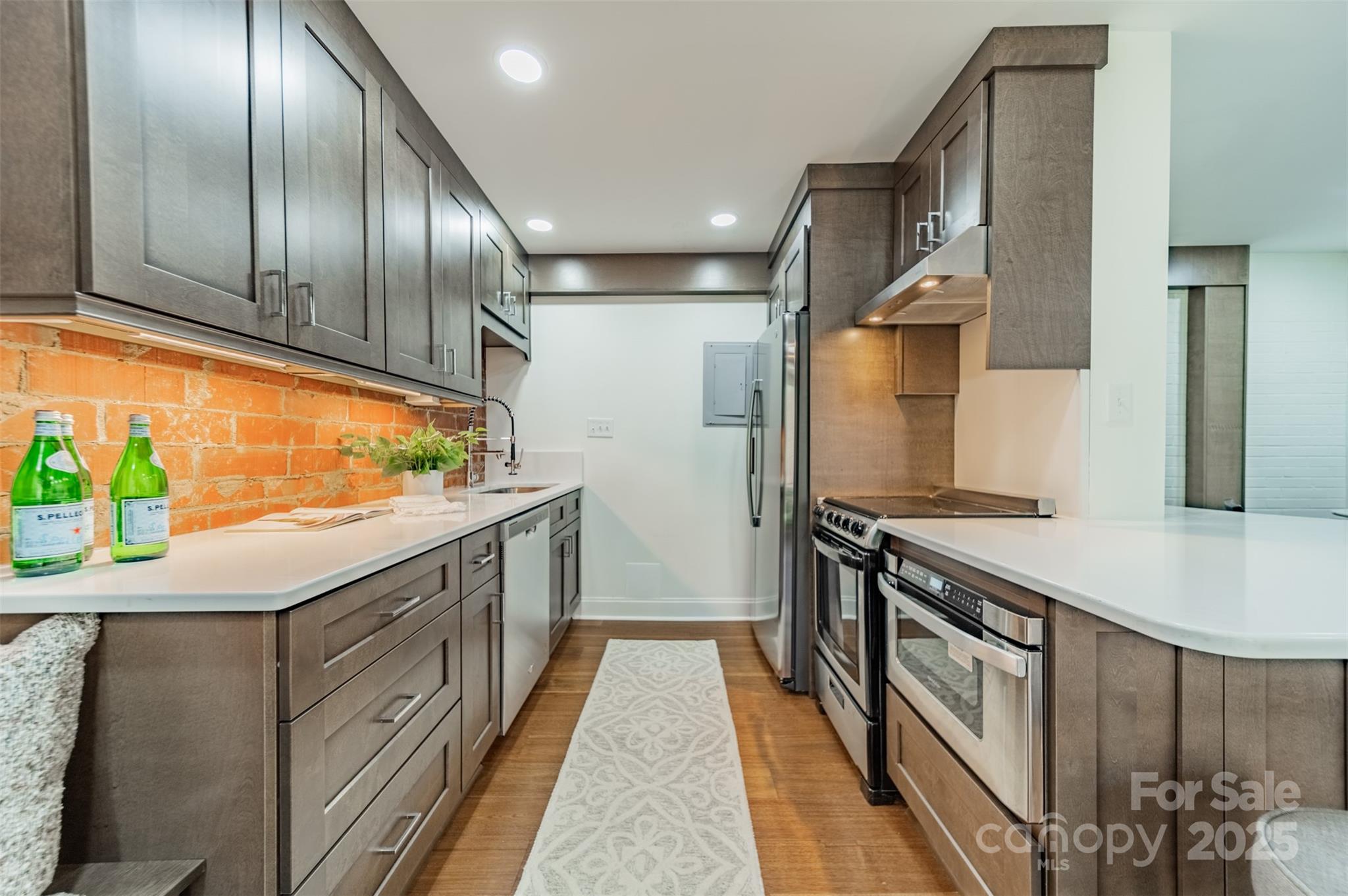 400 Queens Road, Unit D6 Charlotte, NC 28207 - Photo 9 of 26 a kitchen with stainless steel appliances granite countertop lots of counter top space and wooden floor