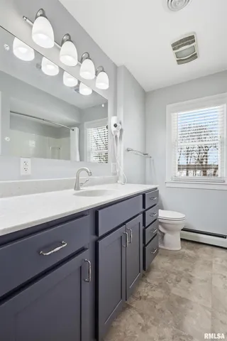 a bathroom with a sink a toilet and a large mirror