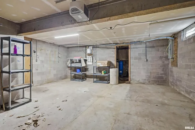 a room with water heater and wooden cabinets